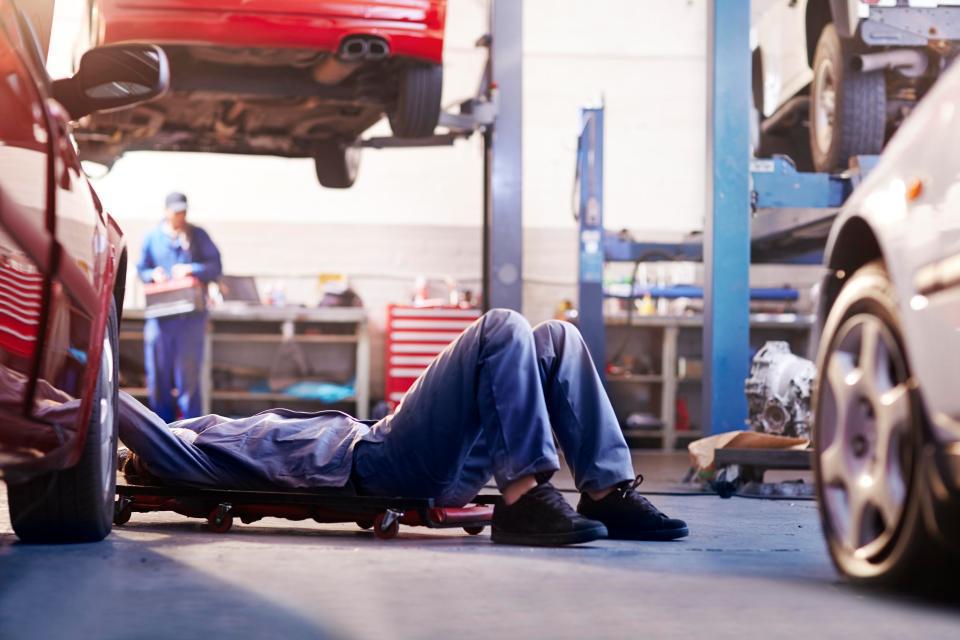 Garagiste sous une voiture