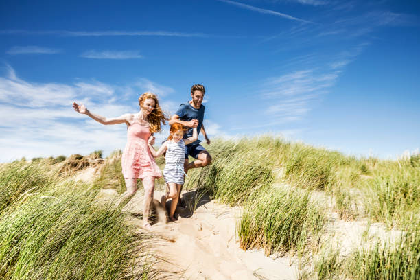 Famille qui court dans le sable 