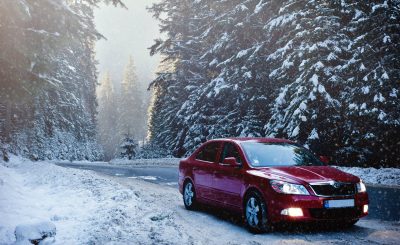 Voiture qui roule sur une route enneigée en hiver