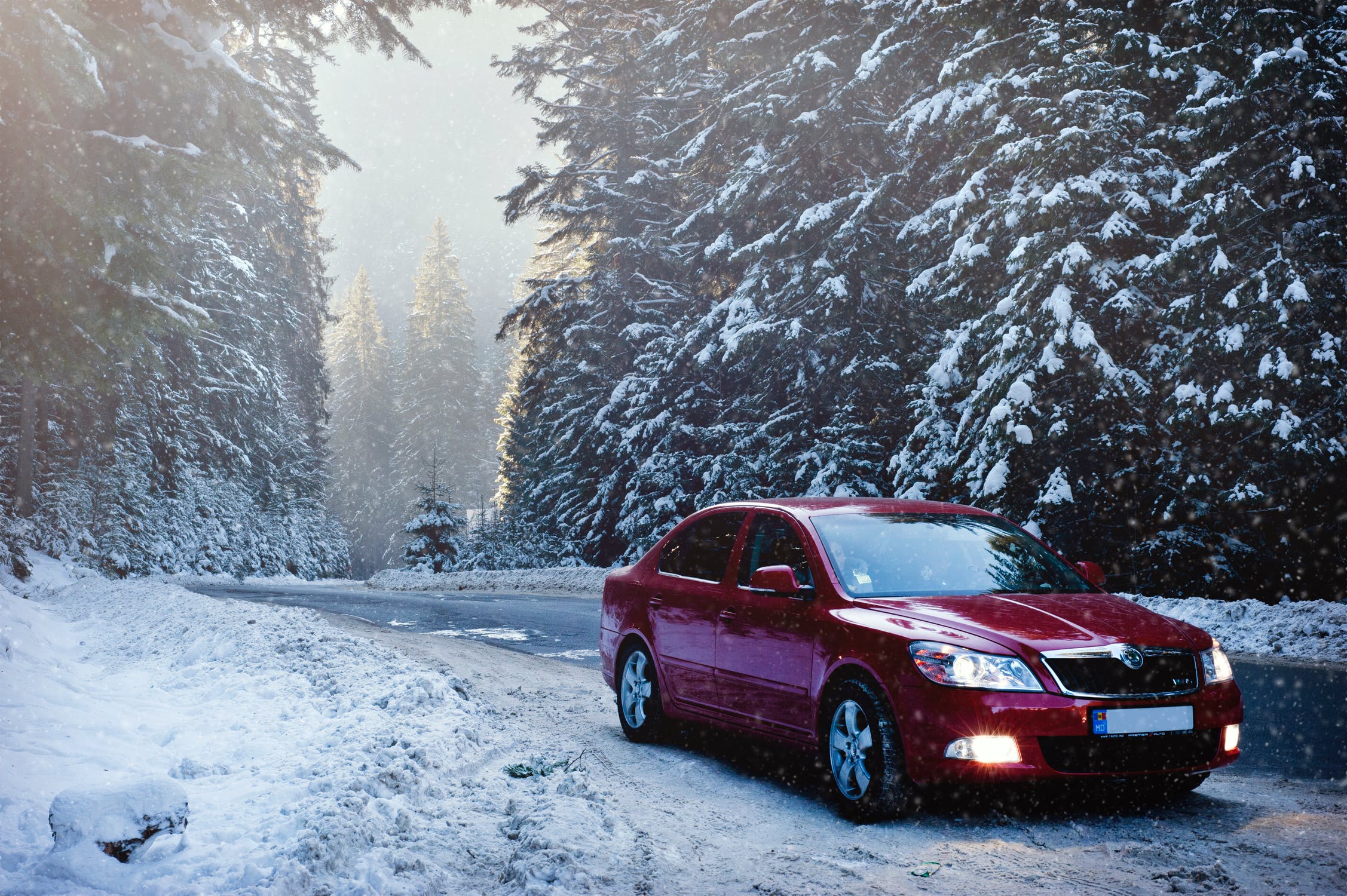 Voiture qui roule sur une route enneigée en hiver